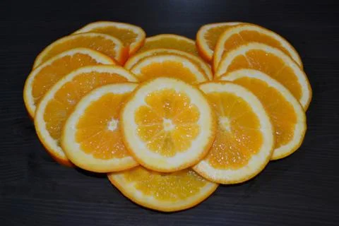 Slices of ripe oranges posed in a shape of a heart. Stock Photos