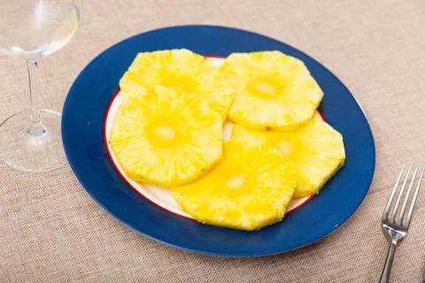 Slices of ripe pineapple fruit served on a ceramic plate in cafe 写真素材
