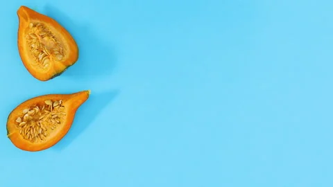 Slices of ripe pumpkin appear on left side of blue theme. Stop motion 스톡 동영상 141798949