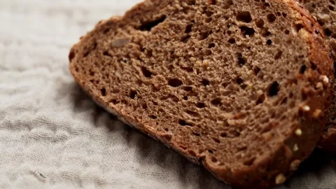Slices of rustic German rye bread on a natural linen fabric Stock Footage 333622005