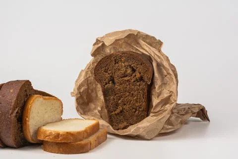 Slices of rye and wheat bread are laid out on a white background. Wrap half a Foto stock