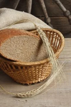 Slices of rye bread and ears of corn on a wooden table Foto stock
