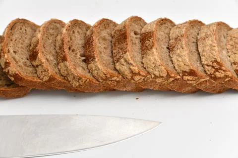 Slices of rye bread and kitchen knife on white background 000012602 Foto stock