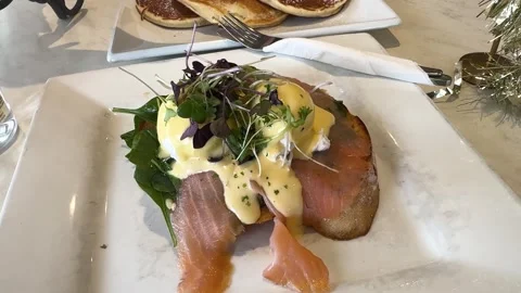 Slices of salmon and egg Benedict breakfast served in cafe in New Zealand Stock Footage 325561604