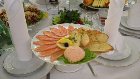 Slices of salmon with bread served on plate on white table Stock Footage 217708634
