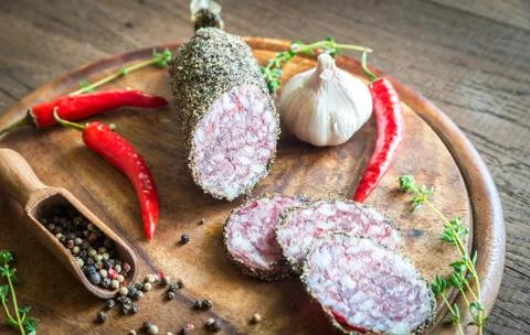 Slices of saucisson on the wooden board Stock Photos