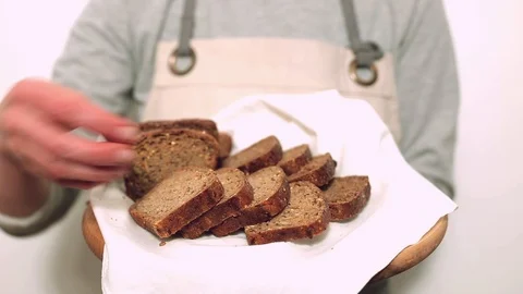 Slices of sliced black rye bread in the hands of a baker. Stock Footage 101155102