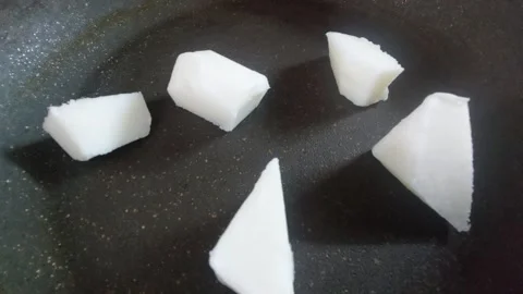 Slices of solid fat melting on a hot frying pan Vídeo Stock 334837709