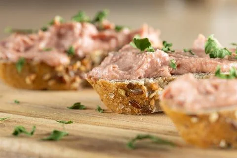 Slices of spreadable pt made with red onion and butter on rustic bread on w.. Stock-Fotos