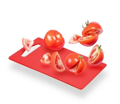 Slices of tomatoes fall on the kitchen board Stock Photos