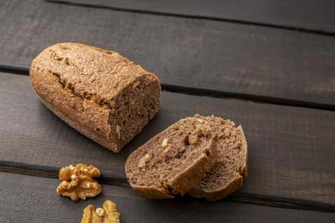 Slices of walnut sourdough bread on dark wooden background with copy space. 库存照片