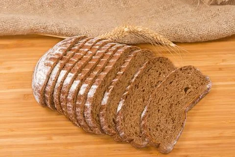 Slices of wheat rye brown bread against the wheat ears Foto stock