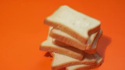 Slices of white bread falling on orange background. 库存影片 143927645