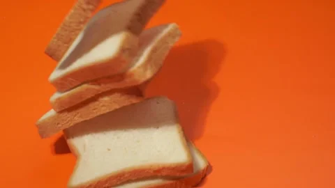 Slices of white bread falling on orange background. 库存影片 143927655