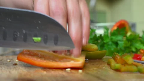 Slicing and dicing  raw bell pepper on a cutting board Stock Footage 135546433