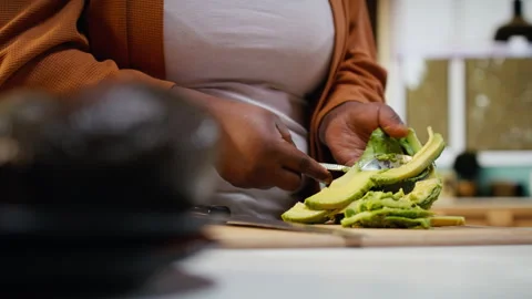 Slicing avocado for toast, close up, cooking video, woman at counter Stock Footage 333611243