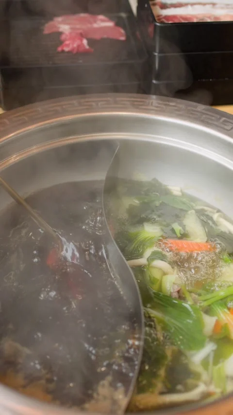 Slicing Beef Cooked in Dual Broth Hotpot at Dining Table Vídeos de archivo 321793197