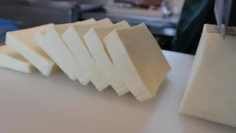 Slicing a Block of White Cheese on a Cutting Board Stock Footage 331955686