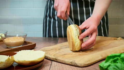 Slicing a bread bun in two for a burger in 4K. Stock Footage 153821140