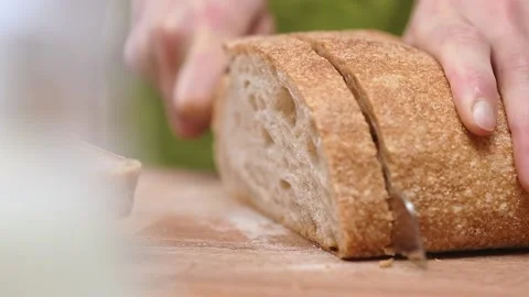 Slicing bread on cutting board, slow motion. Stock Footage 154329010
