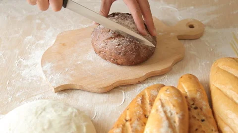 Slicing Bread. Cutting Slice of home Bread on Wooden Boards Cut the Bread Stock Footage 65517259