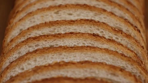 Slicing bread with a focus on the texture and structure of each slice in a Stock Footage 327613217