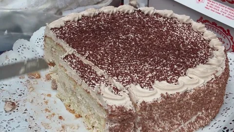 Slicing a brown cream cake Stock Footage 84155106