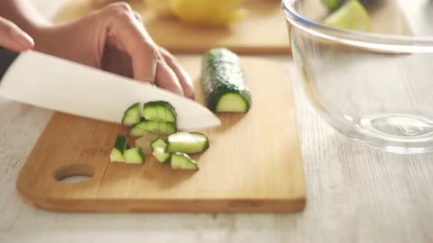 Slicing with a ceramic knife green fresh cucumber Stock Footage 150228340