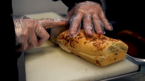Slicing a cheesy hoagie roll Stock Footage 126529902