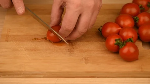 Slicing cherry tomatoes on a cutting board. Stock Footage 130152264