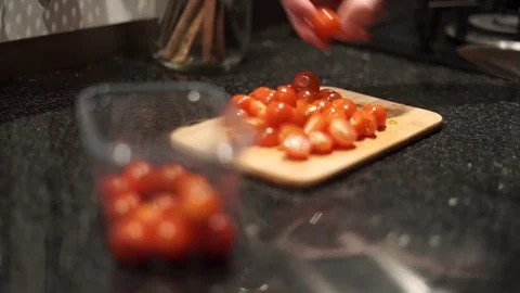 Slicing cherry tomatoes with knife in a kitchen Stock Footage 75352107