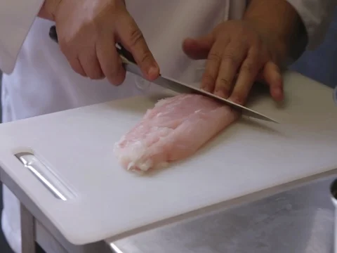 Slicing Chicken breast on a kitchen table Stock Footage 80679292