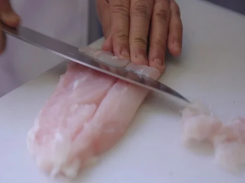 Slicing Chicken with a knife on a kitchen table 1 Stock Footage 80679074