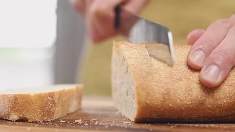 Slicing ciabatta bread on cutting board, slow motion. Stock Footage 157540177