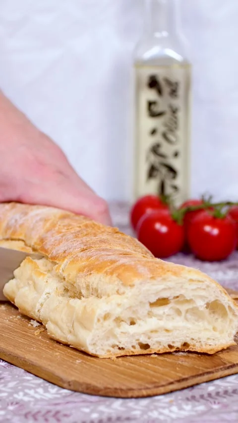 Slicing ciabatta bread on cutting board, slow motion vertical 4k video Stock Footage 281967194