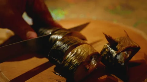 Slicing cold-smoked mackerel without head Stock Footage 168944691