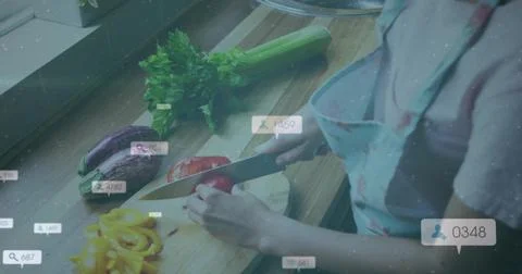 Slicing cook patterned-apron cutting red pepper at home counter, chef knife, UI Stock Photos