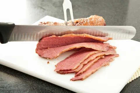 Slicing Corned Beef on a White Plastic Cutting Board Stock Photos