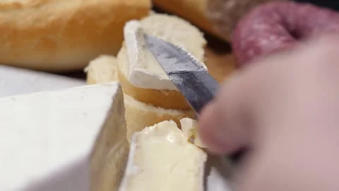 Slicing Creamy Cheese with Fresh Bread and Sausages Vidéo 330693606