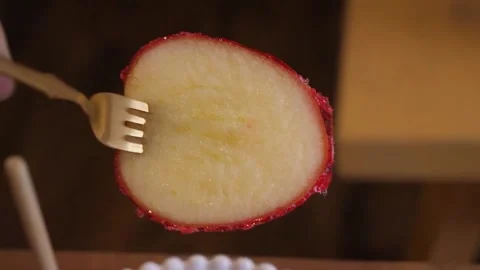 Slicing a Crispy Candy Apple Covered in Glossy Red Candy Shell Stock Footage 345292847