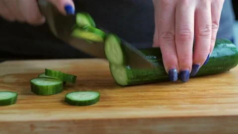 Slicing cucumber close-up. women's hands cut vegetables with a knife Stock Footage 167797053