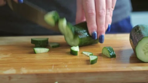 Slicing cucumber close-up. women's hands cut vegetables with a knife Stock Footage 169532115