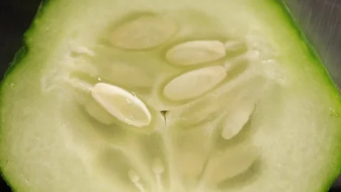 Slicing cucumber . Macro . On a black background. Stock-Footage 74075799