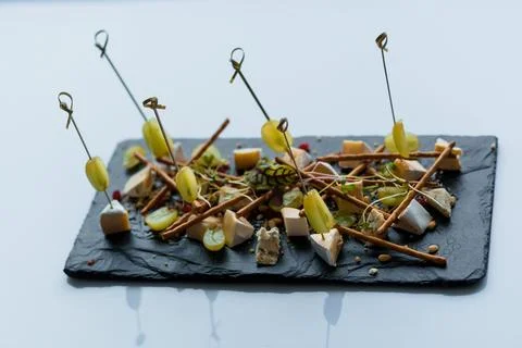 Slicing different types of cheese and grapes. Appetizer with cheese and grapes Stock Photos