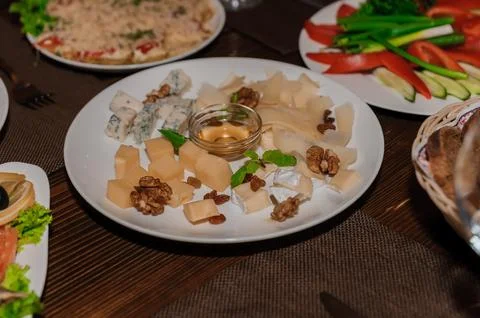 Slicing different types of cheese on a buffet table. Festive table Stock Photos