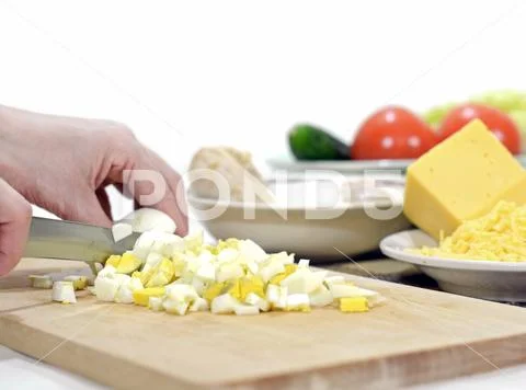 Slicing eggs for cooking vegetable salad with boiled chicken Stock Photos