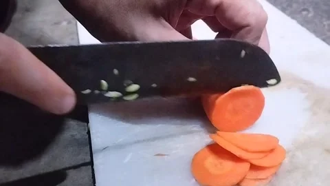 Slicing Fresh Carrots with a Kitchen Knife Stock Footage 321785960