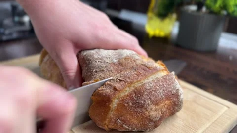 Slicing fresh crispy ciabatta bread on a kitchen board Stock-Footage 310502099