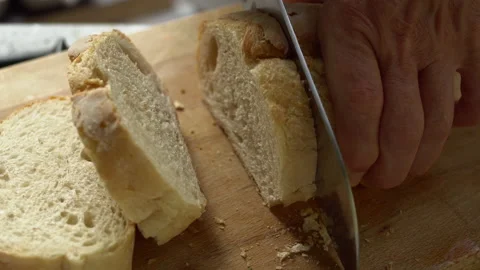 Slicing fresh crispy white bread on a wooden cutting board 動画素材 136559202