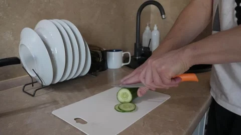 Slicing fresh cucumber in the kitchen Stock Footage 317051929